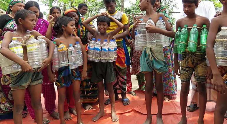 Människor återanvänder plastflaskor för att göra flytvästar i översvämningsdrabbat område i Bangladesh. Foto: Lydia Dackerud